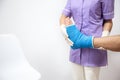 Female doctor in a blue medical gown checking broken leg on male patient Royalty Free Stock Photo
