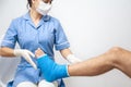 Female doctor in a blue medical gown checking broken leg on male patient Royalty Free Stock Photo