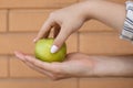 Close-up of a man`s palm with a green apple on it while a woman`s hand picks it up Royalty Free Stock Photo