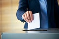 Close up of man\'s putting election vote paper into balloting box