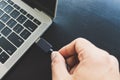 Close up of a man`s right hand Going to connect the USB cable, take the external data into the laptop