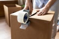 Close up man sealing cardboard box with adhesive tape Royalty Free Stock Photo