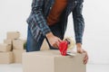 close up man sealing cardboard box with duct tape. High quality beautiful photo concept Royalty Free Stock Photo