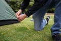 Close up of a man setting up a tent for camping.