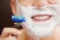 close-up. a man shaves with a safety razor with shaving foam. Royalty Free Stock Photo