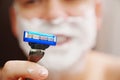 close-up. a man shaves with a safety razor with shaving foam. selective focus. Royalty Free Stock Photo