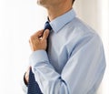 Close up of man in shirt adjusting tie on neck Royalty Free Stock Photo
