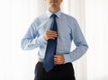 Close up of man in shirt adjusting tie on neck Royalty Free Stock Photo