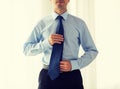 Close up of man in shirt adjusting tie on neck Royalty Free Stock Photo