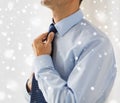 Close up of man in shirt adjusting tie on neck Royalty Free Stock Photo