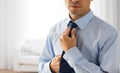 Close up of man in shirt adjusting tie on neck Royalty Free Stock Photo