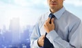 Close up of man in shirt adjusting tie on neck Royalty Free Stock Photo