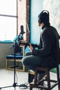 Close up of a man singer sitting on a stool in a headphones with a guitar recording a track in a home studio Royalty Free Stock Photo