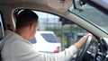 Close up of man sitting in car waiting for daughter looking away. Rear of male in driver's seat in vehicle waits for Royalty Free Stock Photo