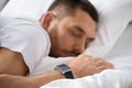 Close up of man with smart watch sleeping in bed