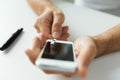 Close up of man with smartphone making blood test