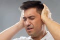 Close up of man suffering from noise closing ears