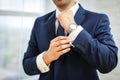 Close-up of man in suit with watch on his hand fixing his cufflink. groom bow tie cufflinks