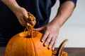 Male hands carving pumpkin taking out seeds