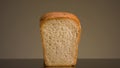 Close-up of man taking bread. Stock footage. Loaf of white bread with cut piece on isolated background. Man takes piece Royalty Free Stock Photo