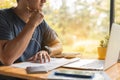 Close up man is thinking while writing note with laptop Royalty Free Stock Photo