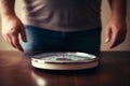 Close-up of a man about to step on a bathroom scale. Symbol of weight management and health