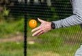 Close up of man tossing a pickleball about to serve