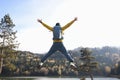 Man tourist with open arms jumping, lake and mountains on background Royalty Free Stock Photo