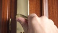 Close-up of a man turns a bronze doorknob, unlocks the lock