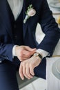Close-up of a man in a tux fixing his cufflink. groom bow tie cufflinks. Groom adjusts cufflinks, groom in a blue suit straightens Royalty Free Stock Photo