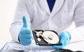 Man in uniform hold disassembled hard drive from computer, hdd and reader, show thumbs up Royalty Free Stock Photo