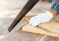 Close up the man use hand saw cutting wood board Royalty Free Stock Photo