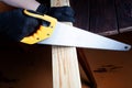 Close up the man use hand saw cutting wood board in the carpenter shop. Royalty Free Stock Photo