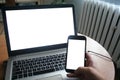 Close up of man using blank cell phone and laptop sending massages shopping online. The man works at the computer Royalty Free Stock Photo