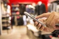 Close up of a man using mobile phone in clothing store