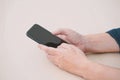 Close up of a man using mobile smart phone on wood table. Royalty Free Stock Photo