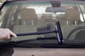 Close-up of man using squeegee to clean the windshield of a car with a GPS visable inside on dash Royalty Free Stock Photo