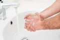 Close up of man washing hands with soap under faucet running water Royalty Free Stock Photo