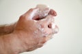 Close up of man washing his hands with a bar of soap and soapy suds Royalty Free Stock Photo