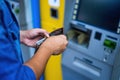 Close-up of man wearing blue jean with an open black wallet , using credit card to withdrawing money from ATM machine. Finance Royalty Free Stock Photo