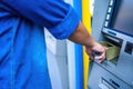 Close-up of man wearing blue jean, using credit card to withdrawing money from ATM machine. Finance and business concept Royalty Free Stock Photo