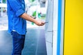 Close-up of man wearing blue jean, using credit card to withdrawing money from ATM machine. Finance and business concept Royalty Free Stock Photo