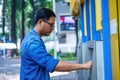 Close-up of man wearing blue jean, using credit card to withdrawing money from ATM machine. Finance and business concept Royalty Free Stock Photo