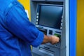 Close-up of man wearing blue jean, using credit card to withdrawing money from ATM machine. Finance and business concept Royalty Free Stock Photo