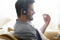 Close up man wearing headphones enjoying music, pretending playing guitar Royalty Free Stock Photo