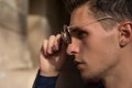 close-up of a man who takes off his sunglasses,male portrait in profile, where he holds glasses, touches glasses.buying points Royalty Free Stock Photo