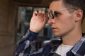 close-up of a man who takes off his sunglasses,male portrait in profile, where he holds glasses, touches glasses.buying points Royalty Free Stock Photo