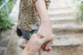 Close up of man and woman hand touching holding togerther on stone step background.