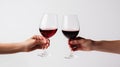 Close up of man and woman hands holding glasses with red wine isolated on white background