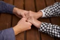 Close up on a man and a woman holding hands at a wooden table. Loving couple holding hands on table, man friend husband Royalty Free Stock Photo